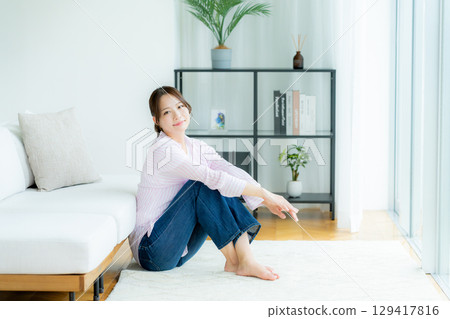 Young woman relaxing in the living room Young woman relaxing in the living room 129417816