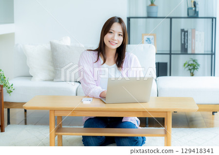 Young woman working on a laptop at home Young woman working on a laptop at home 129418341