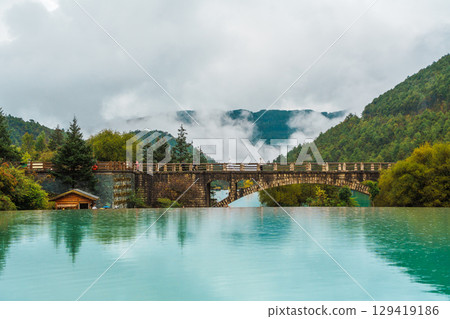 Stone Bridge Over Turquoise Lake in Blue Moon Valley, Yulong Snow Mountain, China Stone Bridge Over Turquoise Lake in Blue Moon Valley, Yulong Snow Mountain, China 129419186
