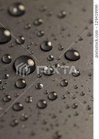 plastic covered with water drops, details of the wet part of an object made of black plastic 129419996