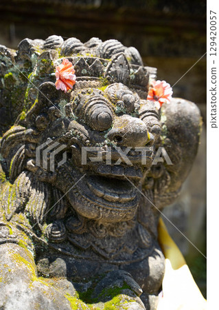 峇裡島一座印度教寺廟內裝飾有花卉的守護雕像 129420057
