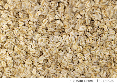oat flakes from oatmeal , a large amount of oat flakes for quick cooking of porridge in boiled hot water, closeup oat flakes from oatmeal , a large amount of oat flakes for quick cooking of porridge in boiled hot water, closeup 129420080