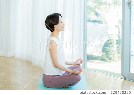 Woman doing yoga in the living room 129420230