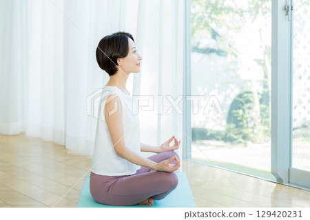 一個女人在客廳做瑜伽 129420231