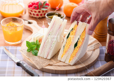 混合三明治和柳橙汁是完美的早餐或午餐，在時尚的咖啡館風格環境中呈現。 129420367