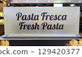 White sign with black lettering for the sale and tasting of fresh pasta. 129420377