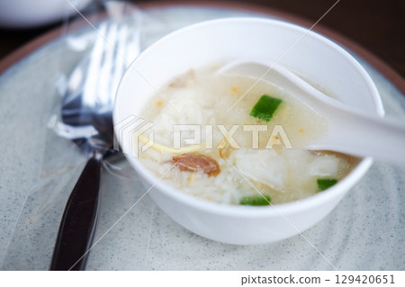 Close up crispy fried Anchovy fish intestines with boiled rice in white bowl. Thai food on wooden table is breakfast in the morning of Thailand Close up crispy fried Anchovy fish intestines with boiled rice in white bowl. Thai food on wooden table is breakfast in the morning of Thailand 129420651
