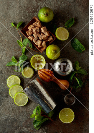 Wooden citrus squeezer, shaker, and ingredients for making summer refreshing drinks. 129420973