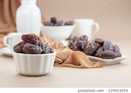 Dates in white dish on a beige background. Dates in white dish on a beige background. 129421054