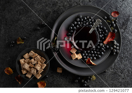 Black chokeberry juice, fresh berries, and pieces of brown sugar. 129421077