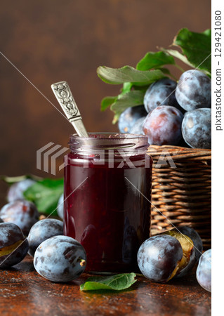 Plum jam and fresh berries on a brown vintage table. 129421080