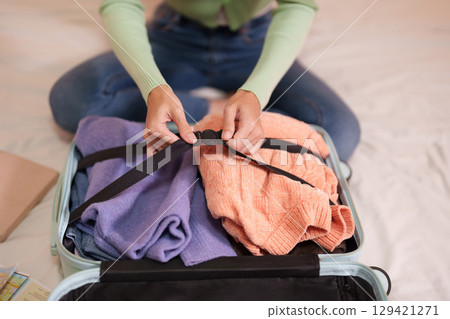 Adult Asian woman prepare travel luggage home bedroom vacation trip journey organization packing essentials 129421271