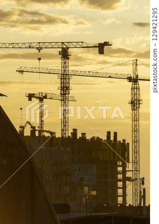 Construction Cranes at Sunset. Building the Future 129421295