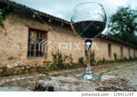 Glass of Red Wine in Front of Stone Wine Cellar in France or Italy Glass of Red Wine in Front of Stone Wine Cellar in France or Italy 129421297