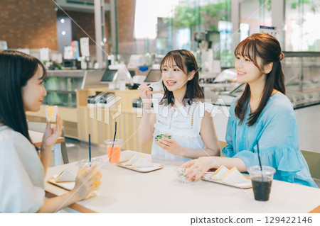 Three women having lunch at a cafe 129422146