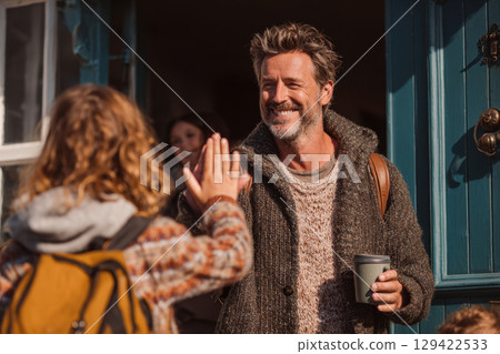 Father saying goodbye to child going to school in morning 129422533