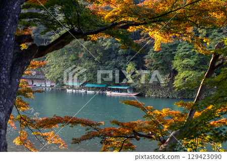Autumn foliage frames a tranquil riverside scene in Arashiyama, Kyoto, Japan Autumn foliage frames a tranquil riverside scene in Arashiyama, Kyoto, Japan 129423090