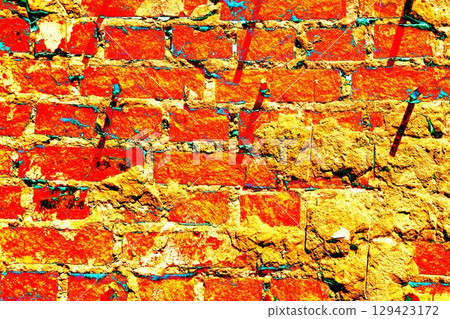 Peeling paint on a brick wall. Old brick wall with cracked peeling paint and metal pins. 129423172