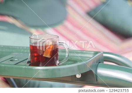 A cup of herbal tea in the country, a glass of tea on the country swing. 129423755