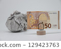 Banknote on the background of a crumpled piece of newspaper on a white background, 129423763