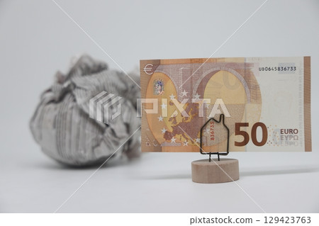 Banknote on the background of a crumpled piece of newspaper on a white background, 129423763