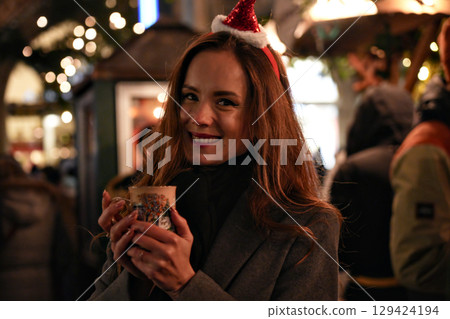 Woman smiling with cup of mulled wine at Munich Christmas market Woman smiling with cup of mulled wine at Munich Christmas market 129424194