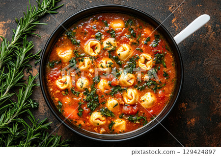 Bowl of pasta with a lot of green herbs and vegetables 129424897