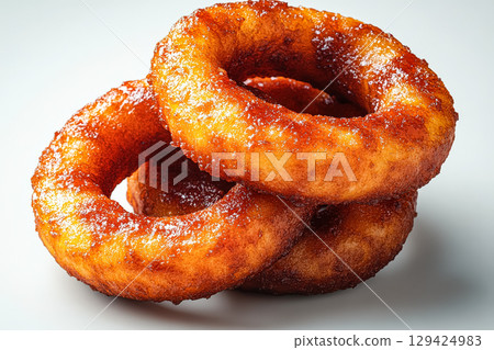 Three donuts stacked on top of each other with a brown glaze Three donuts stacked on top of each other with a brown glaze 129424983