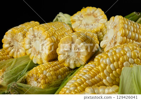 Detailed fresh raw corn cobs with natural texture close-up. 129426041