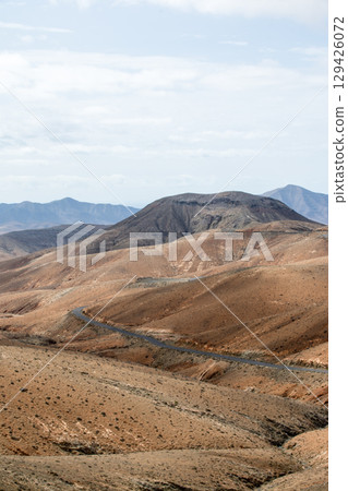 Bare, dry, and bare mountains under bright sunlight in the interior of Fuerteventura Bare, dry, and bare mountains under bright sunlight in the interior of Fuerteventura 129426072