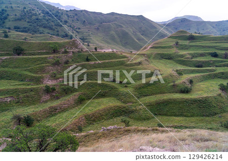 Chokhsky terraces Dagestan. Landscape of mountainous Dagestan with terraced fields and peaks mountains in the distance. 129426214