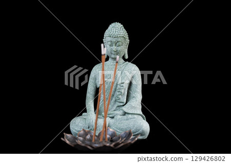 buddha statue with incense sticks on black background buddha statue with incense sticks on black background 129426802