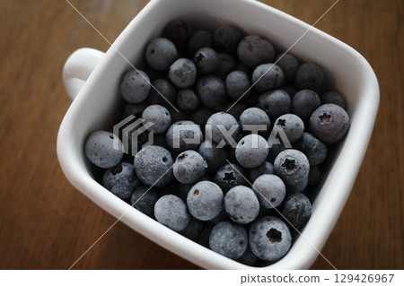 Frozen blueberries in an enamel container 129426967