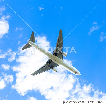 Blue sky and an airplane flying gracefully 129427022