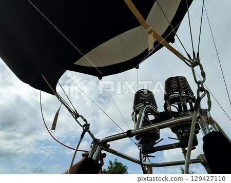 Hot air balloon burners against cloudy sky on a scenic day 129427110