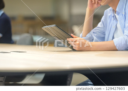 一名男學生正在看平板電腦的個人資料 129427603