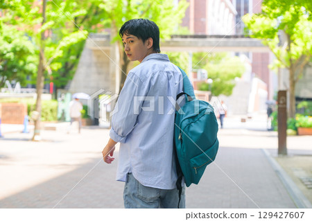 Back view of a male student walking on campus Back view of a male student walking on campus 129427607