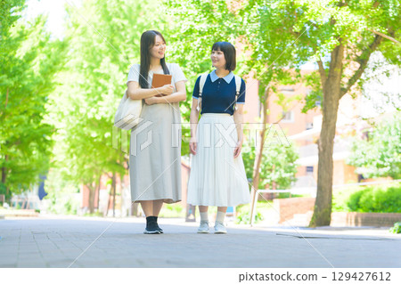 兩名學生在綠色校園裡聊天 129427612