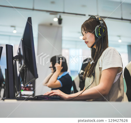 Female college student playing online games with a headset 129427626
