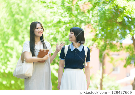 Female college students talking on campus Female college students talking on campus 129427669