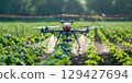 Drone technology enhances agricultural productivity by pouring crops in vibrant field during daytime 129427694