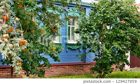 Beautiful wooden blue house with trees nearby. 129427859