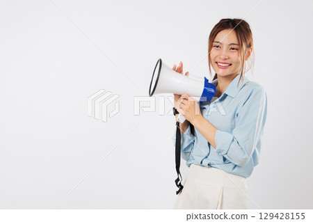 Excited woman makes a public announcement, holding and speaking into her megaphone. She is loudly shouting the news, screaming with her impactful megaphone and open mouth. isolated white background 129428155