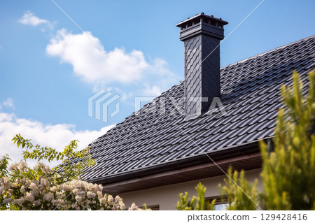 Architectural detail of a contemporary house roof and chimney 129428416