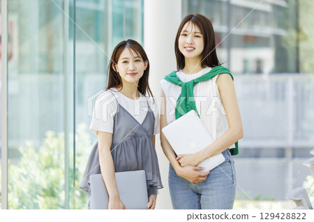 Smiling students standing in a university classroom 129428822