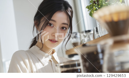 A woman who is making coffee 129429653