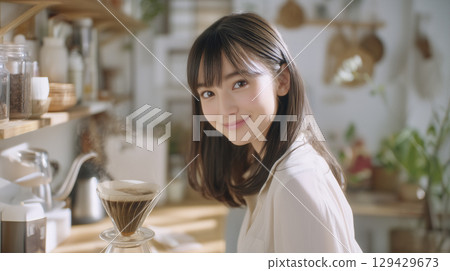 A woman who is making coffee 129429673