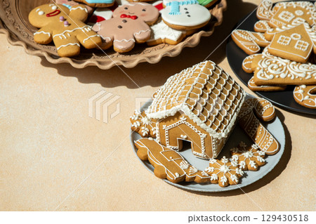 Gingerbread House and Cookies on table. Christmas food baking. Xmas sweets 129430518