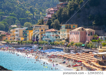 Umbrellas on the beach in summer. Italian holidays on the coast of the Ligurian blue Sea and Mountain rock. Liguria Monterosso. 129430551