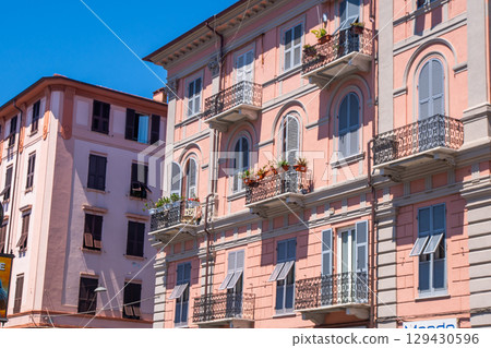 Italian shutters on the windows balcony of pink color house. Open wooden shutter in summer. Italian shutters on the windows balcony of pink color house. Open wooden shutter in summer. 129430596
